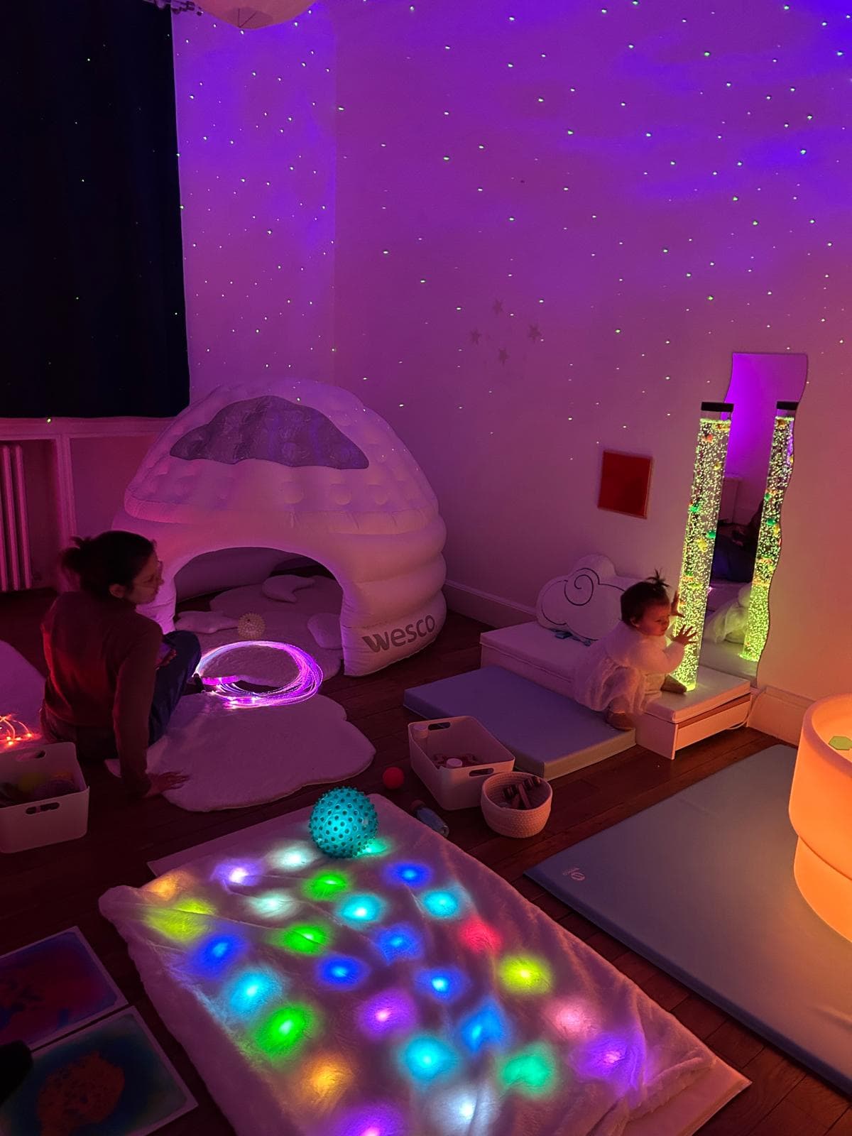 Vue d'ensemble de la salle Snoezelen avec igloo, tapis lumineux et colonnes à bulles