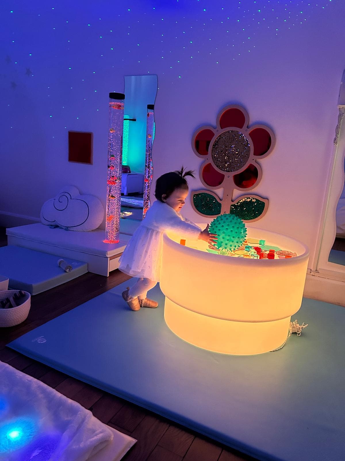 Enfant jouant avec le tambour lumineux et la fleur murale sensorielle